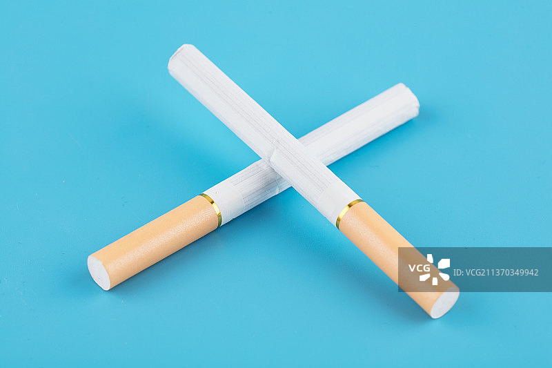 二根香烟在蓝色背景上图片素材