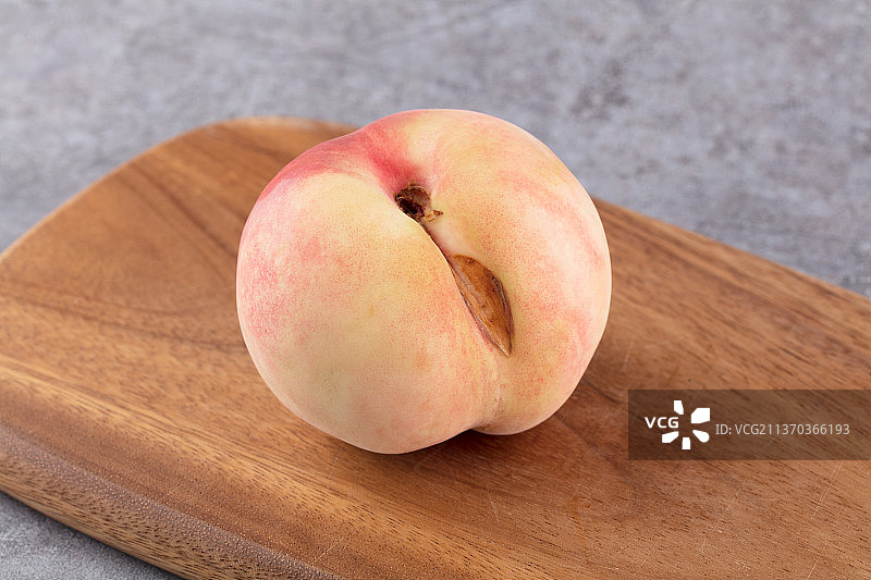 砧板上一颗有瑕疵的桃子图片素材