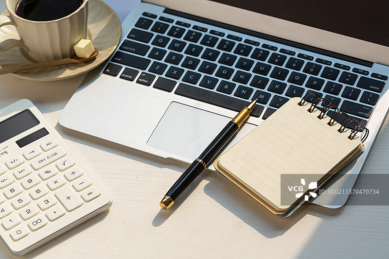 工作台面上的笔记本电脑和笔图片素材