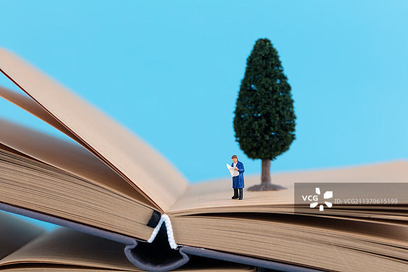 本子上的树下看书者图片素材