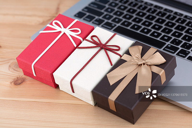 三个礼物盒在笔记本电脑上图片素材