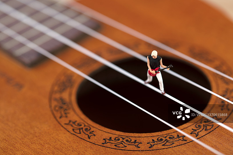 微缩创意尤克里里上玩音乐的人图片素材