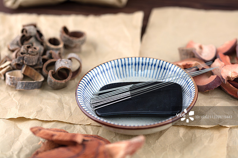 盘子里的中医针灸银针和刮痧片图片素材
