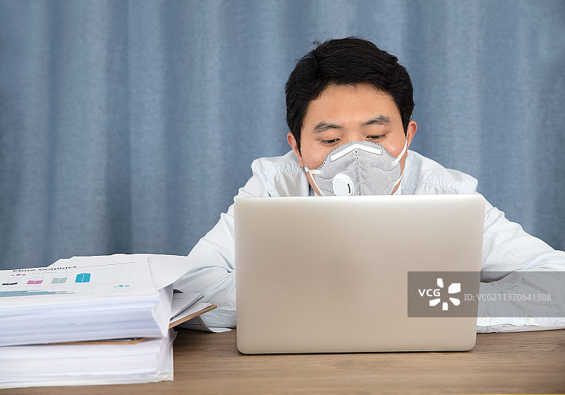 戴着口罩在工作的男士图片素材