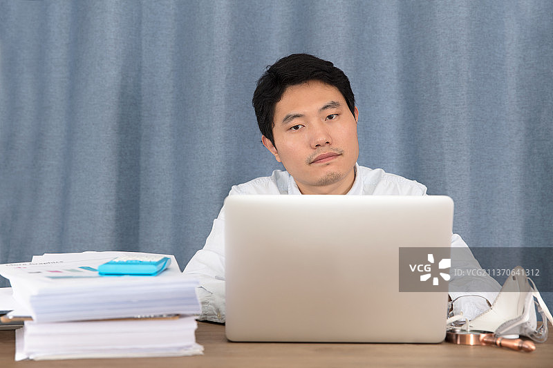 摘掉口罩的室内工作者图片素材