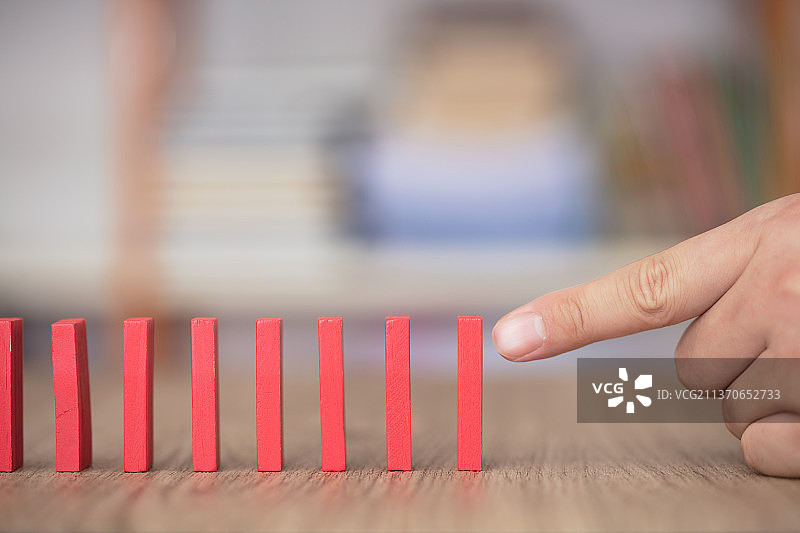 手指头去推倒一排多米诺骨牌图片素材