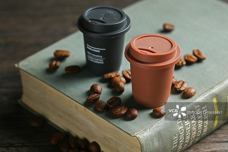 胶囊咖啡和咖啡豆放在复古书上图片素材