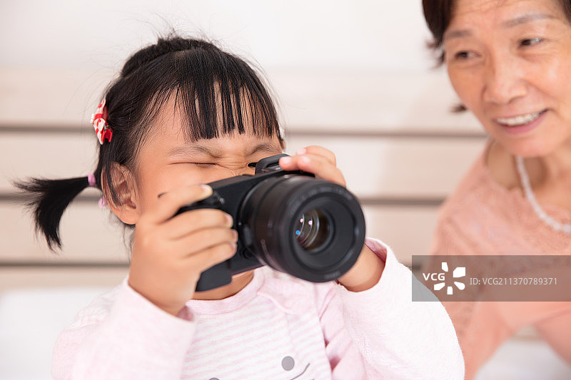 祖母陪着孙女一起练习拍照图片素材