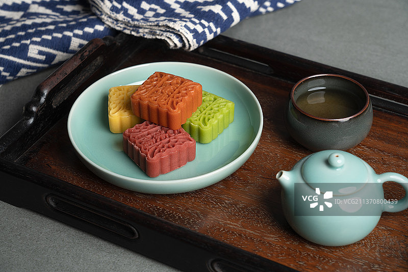 托盘中放着多口味的糕点和青瓷茶壶图片素材