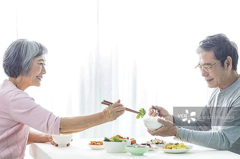 老年夫妻坐在餐桌前用餐图片素材