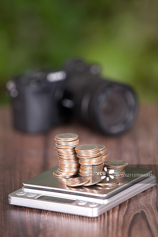 电子秤上一堆美元硬币和数码相机图片素材
