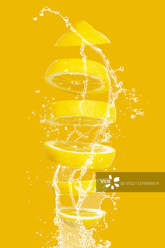 柠檬特写，水花飞溅在黄色背景上，德国奥尔登堡图片素材