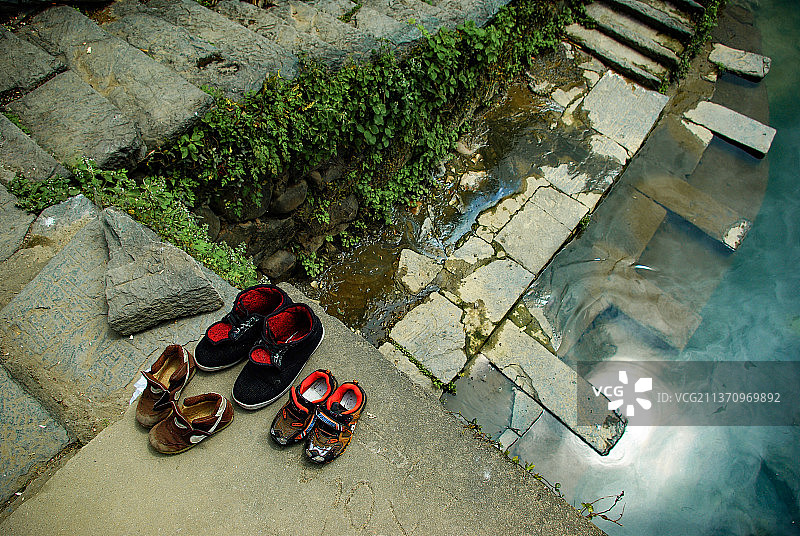 一家+江西上饶市婺源县汪口村。大中小三双鞋，晾晒在古老的石桥边，讲述着怎样的故事。图片素材