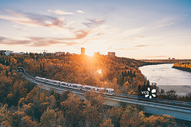 秋季日落：加拿大阿尔伯塔省埃德蒙顿的河上桥梁图片素材