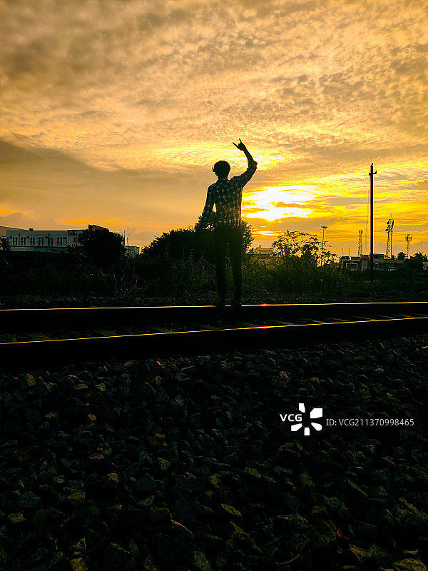 日落时分站在田野上的男孩剪影图片素材