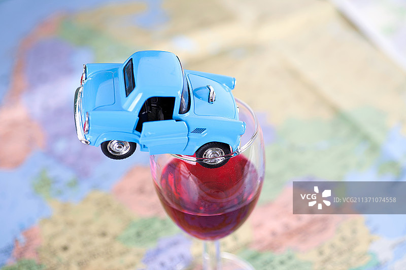 一辆扎进红酒杯里的小汽车模型图片素材