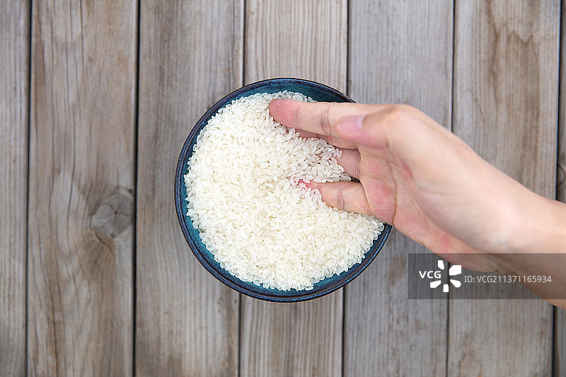 一只手插在碗里的大米里图片素材