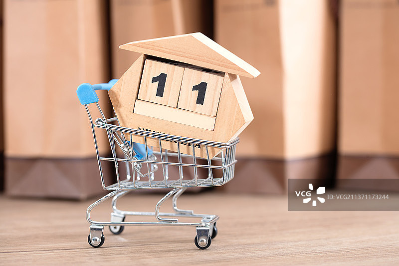 购物车承载着双十一的台历在购物袋前图片素材