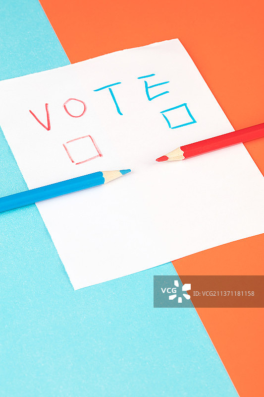一张白纸上写着选举的选项和两支不同颜色的铅笔图片素材