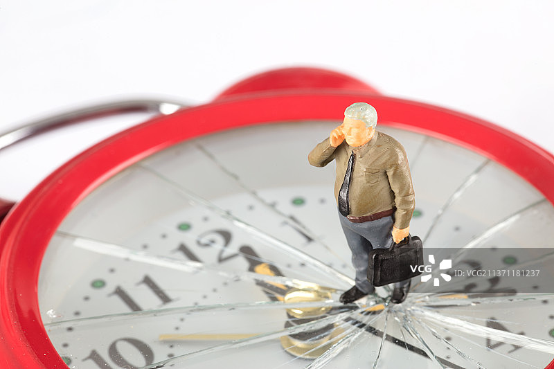 微缩打电话的商人站在破裂的闹钟上图片素材