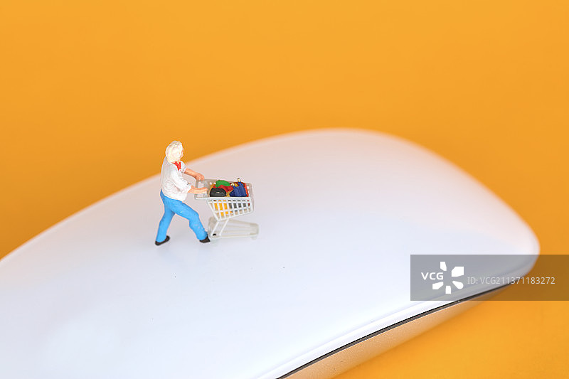 购物者的微缩模型在无线鼠标上图片素材