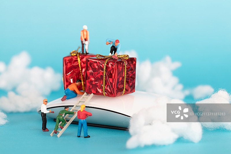 微缩工人人偶模型在忙碌的修理鼠标上的礼物图片素材