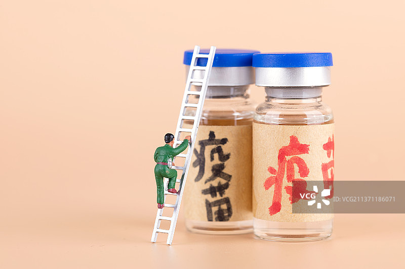 微缩的工程人偶爬向新冠疫苗图片素材