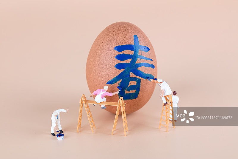 粉刷匠在鸡蛋上粉刷一个春字图片素材