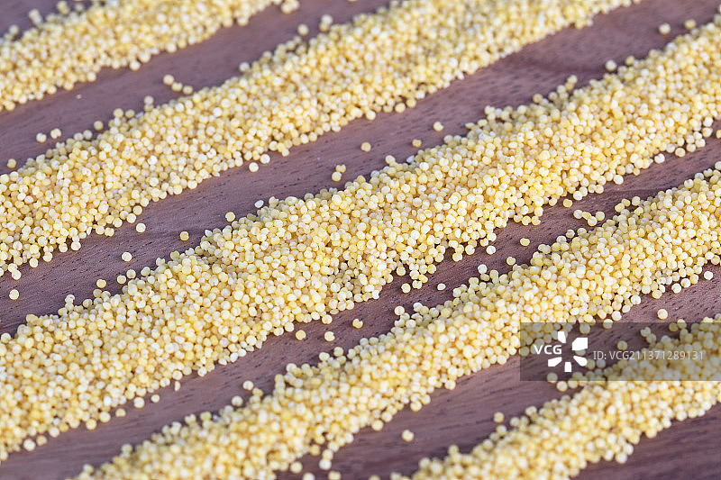 散落成条状的金黄色小米背景图片素材