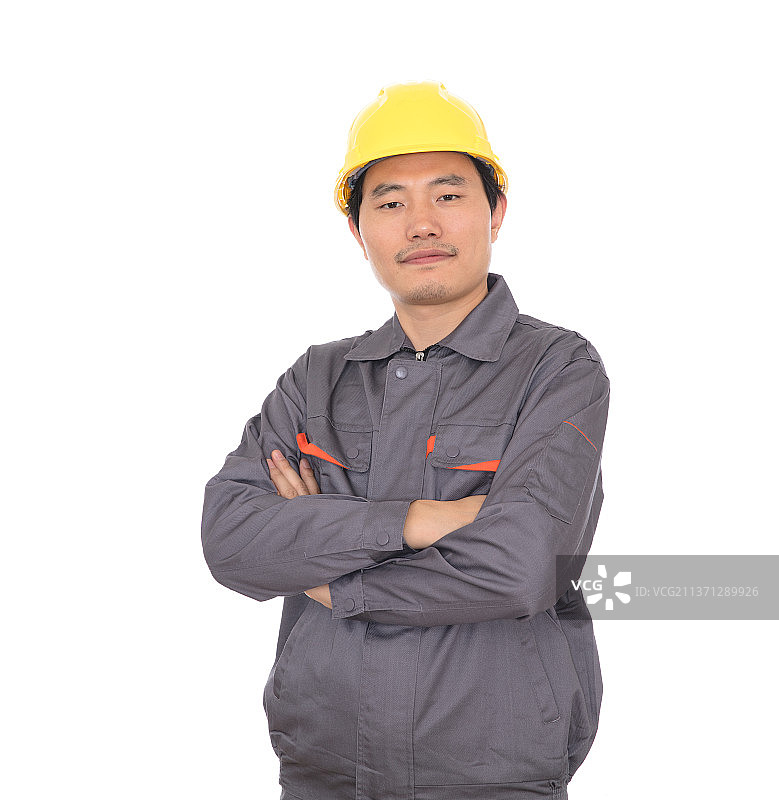 抱着胳膊头戴黄色安全帽的民工站在白背景前图片素材