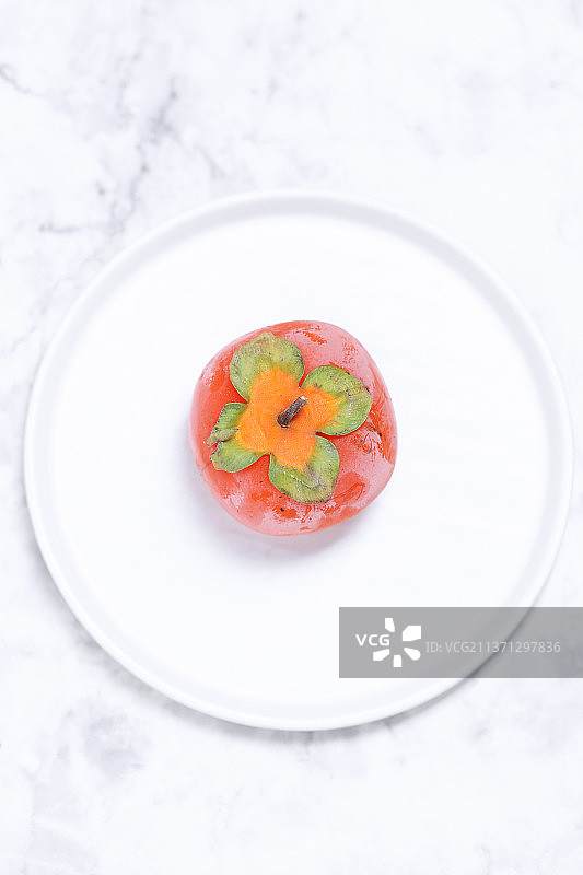 放在白色大理石背景上的柿子图片素材