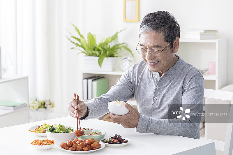 老年男人在餐桌前吃饭图片素材