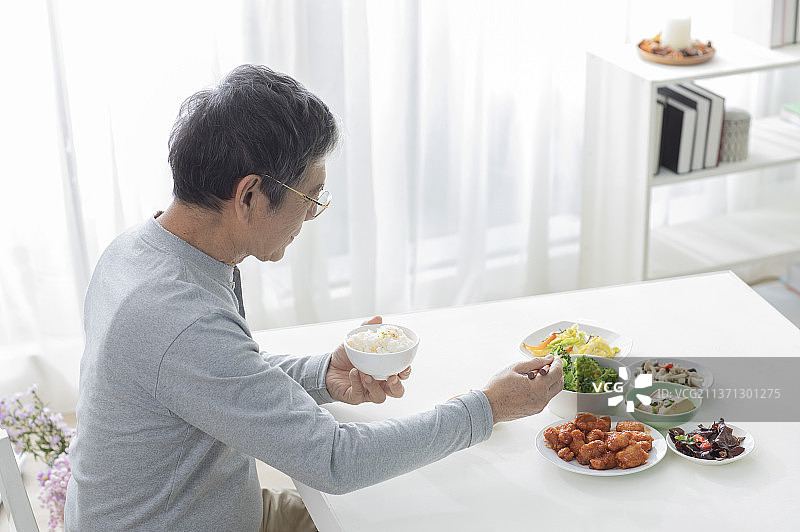 老年男人在餐桌前吃饭图片素材