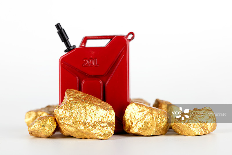 汽油桶和几块碎金子在白背景上图片素材