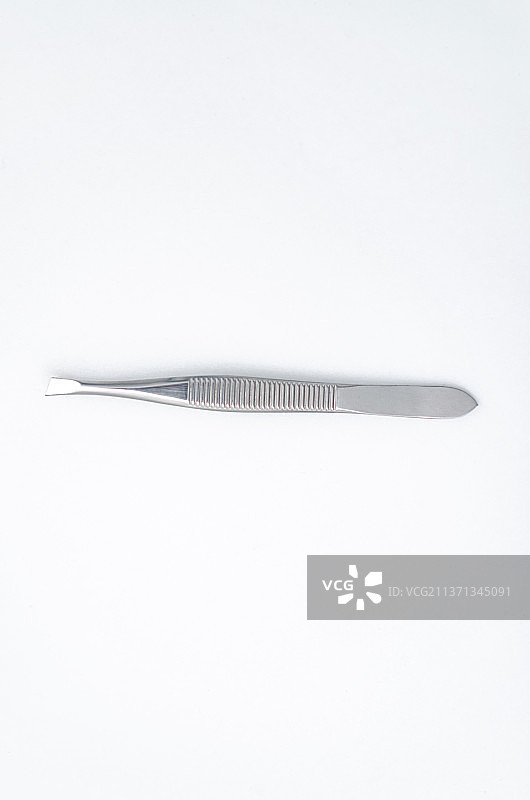 亚洲中国家庭用品拍摄主题，内室内影棚拍摄静物图像，一个不锈钢的镊子，室内无人图像摄影图片素材