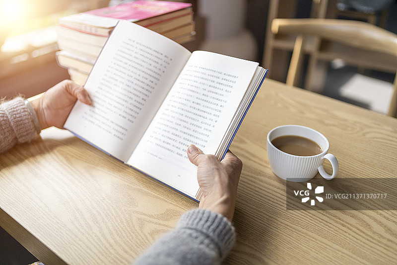 一双女性的手拿着翻开的书本图片素材