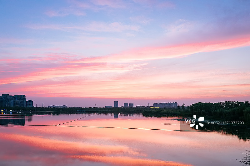 傍晚黄昏中的山东省济南市华山湖公园景区湖面倒影的晚霞图片素材