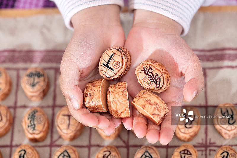 刻着中国篆字的棋子在孩子手里图片素材