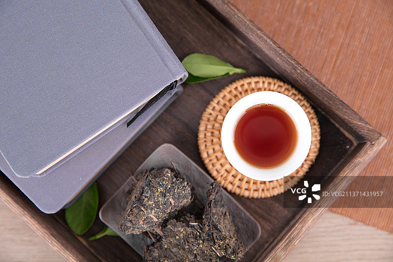 木茶盘里的茯茶茶水和茶叶图片素材