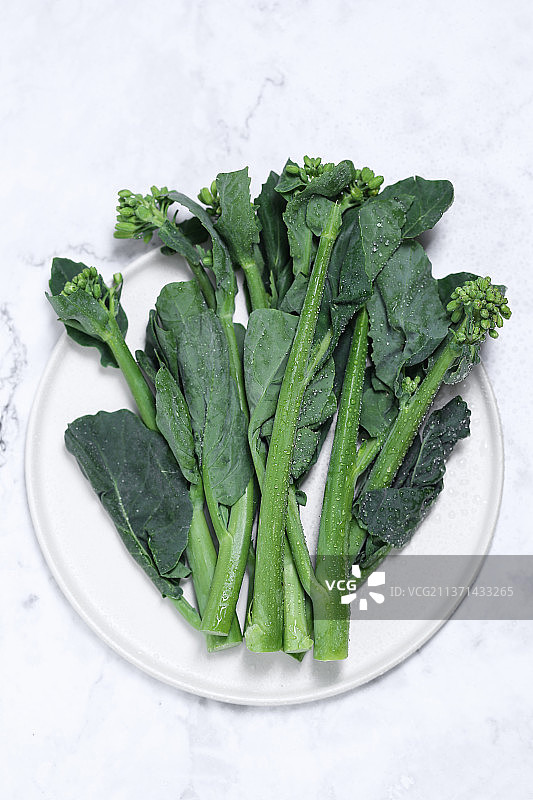 放在白色大理石背景上的新鲜芥兰图片素材