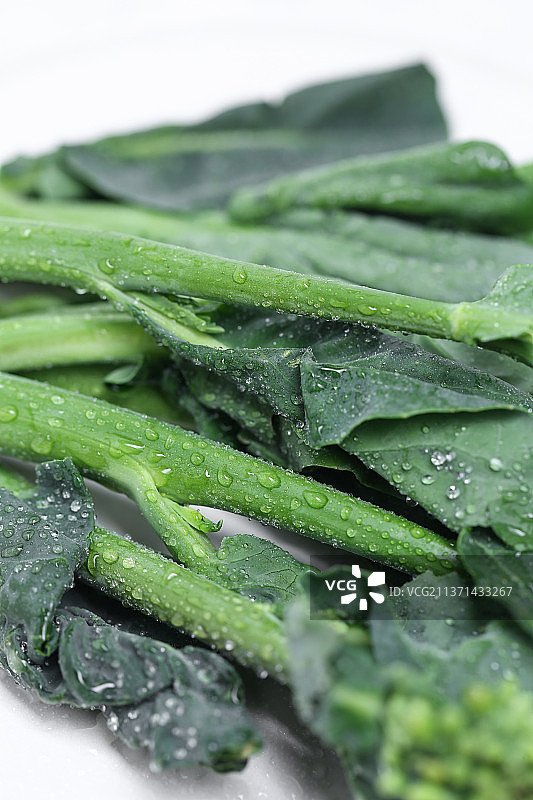 放在白色大理石背景上的新鲜芥兰图片素材