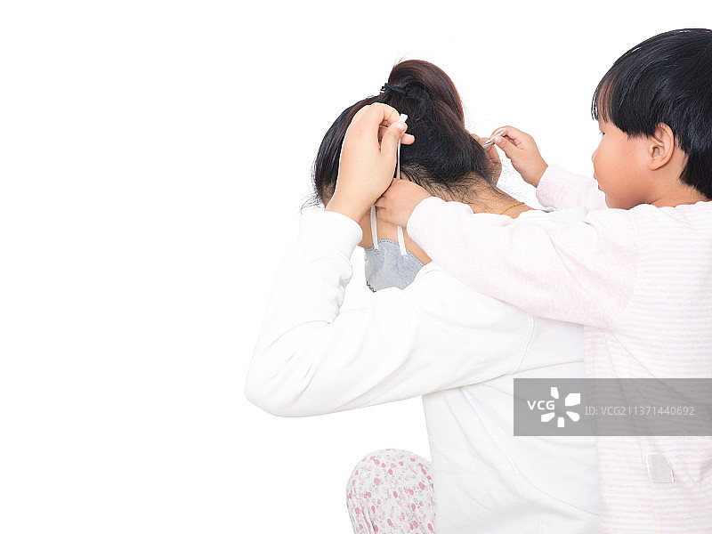 传染病期间女儿在帮妈妈戴上口罩图片素材