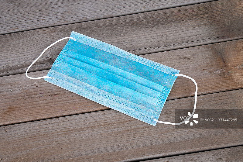 木板背景上一个一次性口罩图片素材