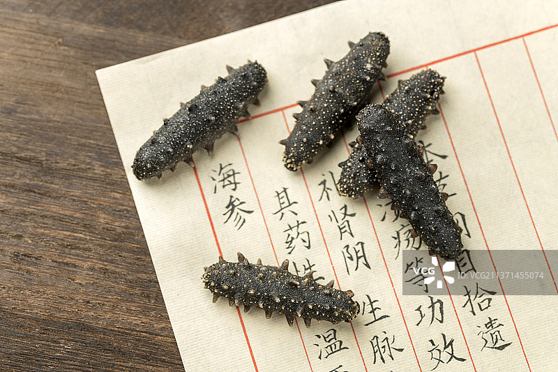 一盘海参摆放在木桌面上特写图片素材