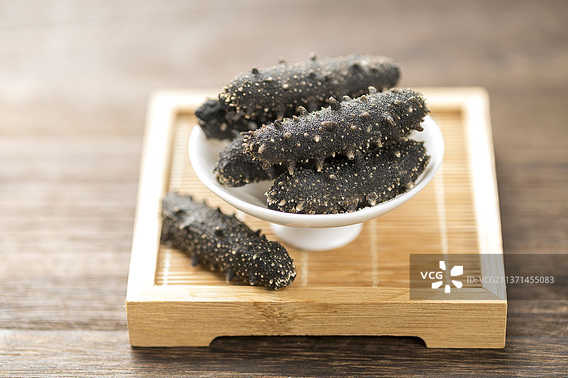 一盘海参摆放在木桌面上特写图片素材