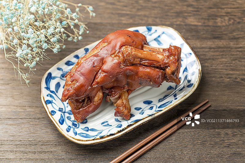 一盘酱猪蹄摆放在木桌面上特写图片素材