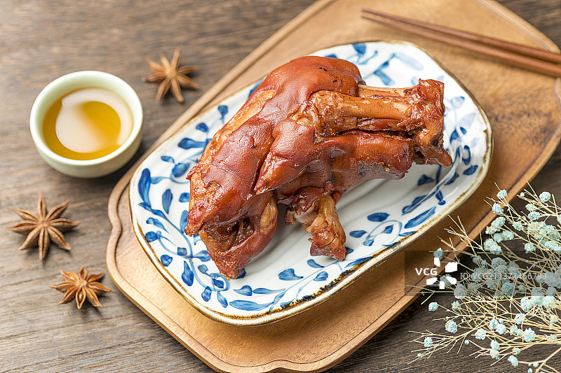 一盘酱猪蹄摆放在木桌面上特写图片素材
