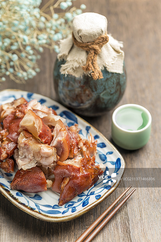 一盘酱猪蹄摆放在木桌面上特写图片素材