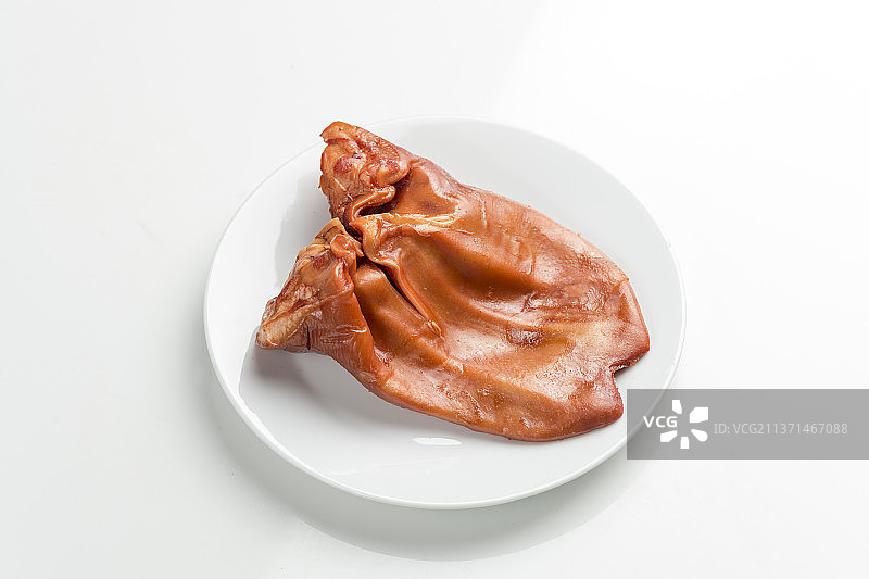 一盘酱猪耳摆放在白色背景上图片素材