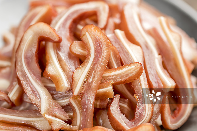 一盘酱猪耳摆放在古窗棂木桌面上特写图片素材